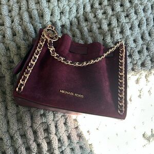 New never used Michael kors purse. Burgandy suede material with gold accents.